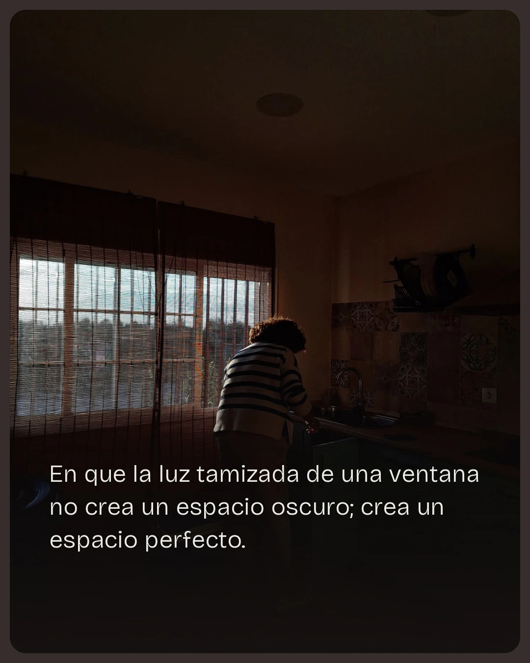 Munya Studio · La luz entra por una gran ventana en una habitación oscura.