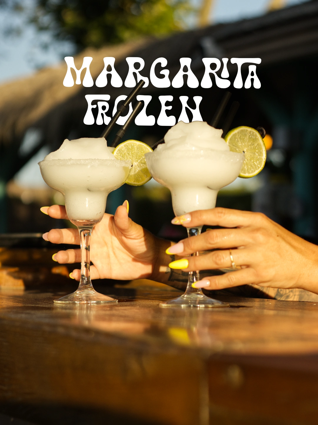 Dos margaritas frozen sostenidas sobre la barra de Zaraho, con la tipografía blanca original.