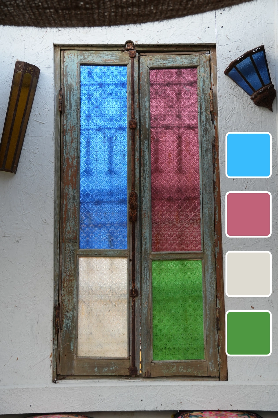 Carrusel de colores de Zaraho: Una puerta con cristales azules, rosas y verdes, con muestras de color a juego.